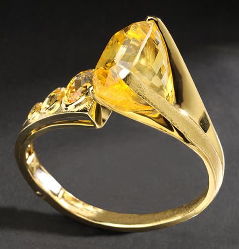 Large yellow gold bracelet featuring large museum yellow sapphires on black background Product Photography