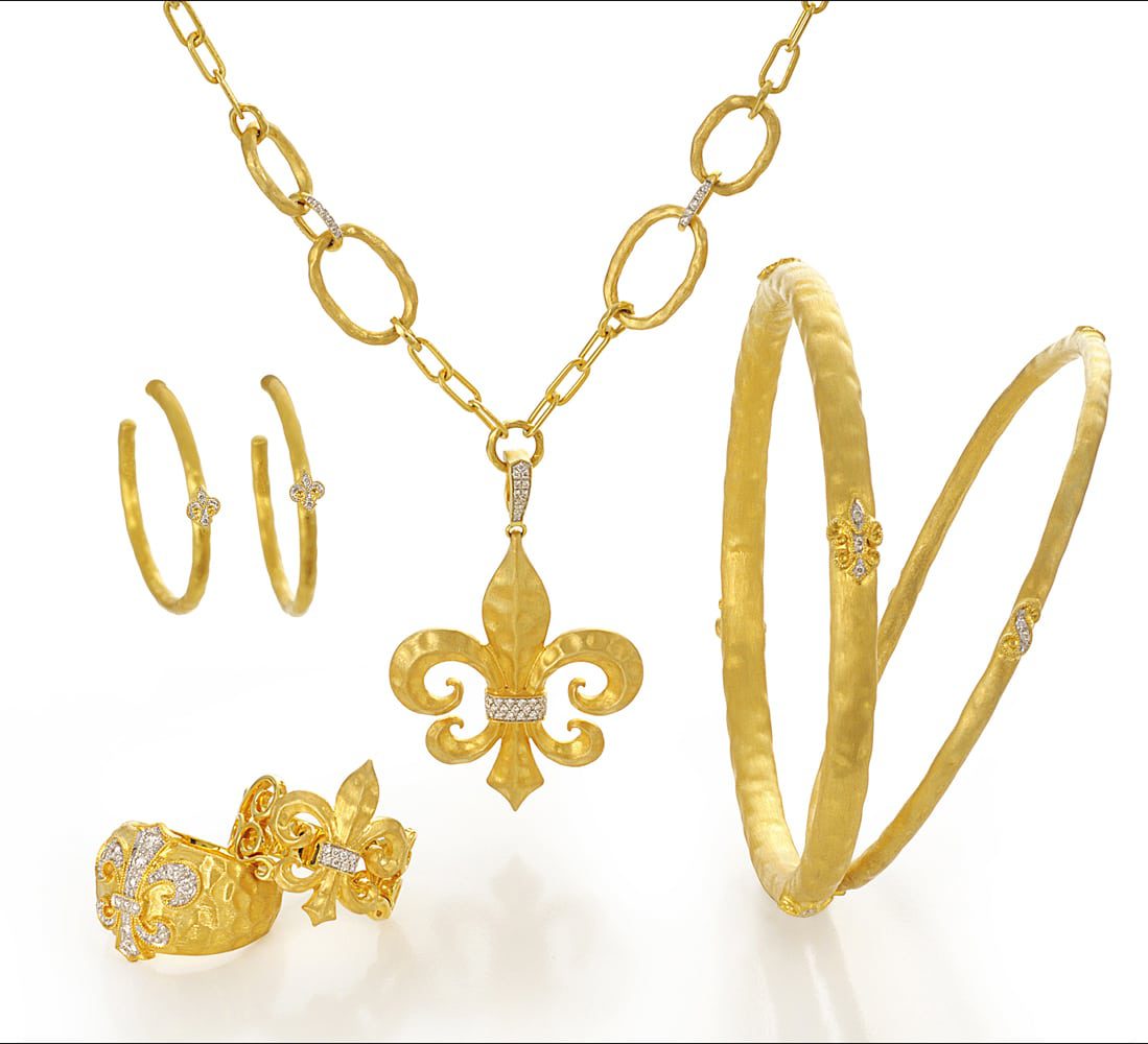 Arrangement of six 18k gold pieces, one large link chain with a flour de lis gold and diamond pendant, gold hoop earrings with diamonds, two gold rings with flour de lis designs and two gold bangles with small diamond flour de lis designs