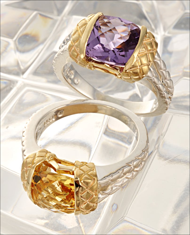 Two white and yellow gold rings, one lying dow and the other standing, with a large purple stone and a large yellow stone