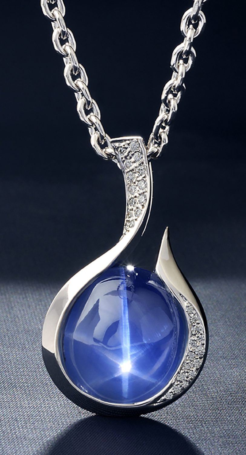 Large star sapphire with star in middle in silver and diamond pendant hanging from silver chain